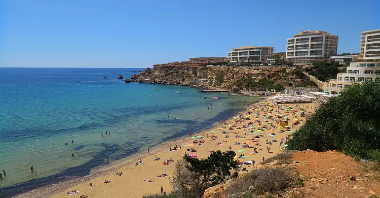 Ein Bild des Golden Bay Strand, dem nahen Hotel und dem türkisbluen Meer im Juni.