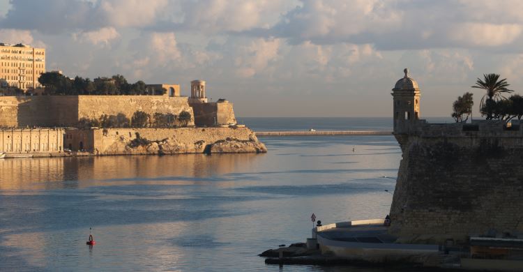 Dunkle Wolken sind am Horizont von Maltas Hauptstadt Valletta zu sehen. Der Blick geht auf die Festungsanlagen der Stadt und die Bucht am Hafen. 