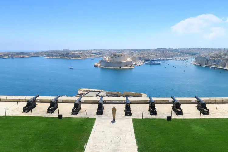 Blick vom Upper Barrakka Garden auf die Kanonen der darunterliegenden Saluting Battery und dem Grand Harbour von Malta. Auf der anderen Seite des Hafens liegt die Stadt Vittoriosa.