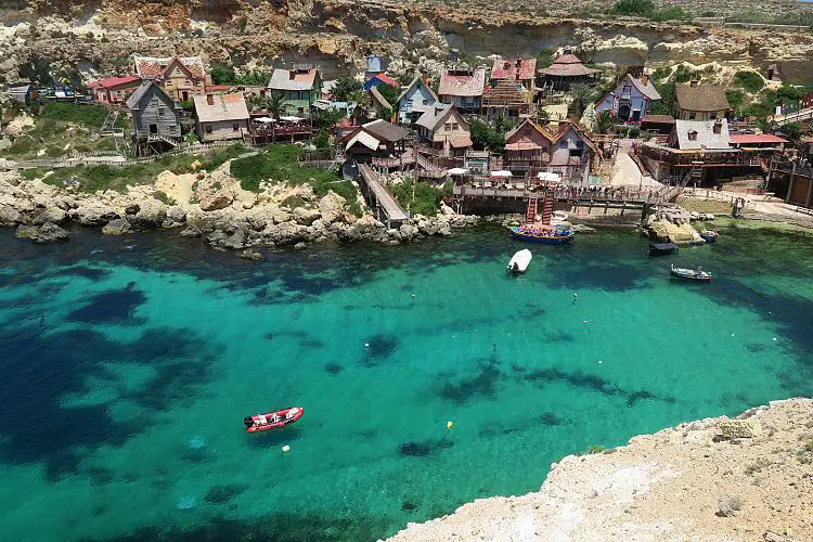 Das Bild zeigt das Popeye Village im Norden von Malta und die türkislaube Bucht und die umliegenden Klippen in dem es sich befindet.