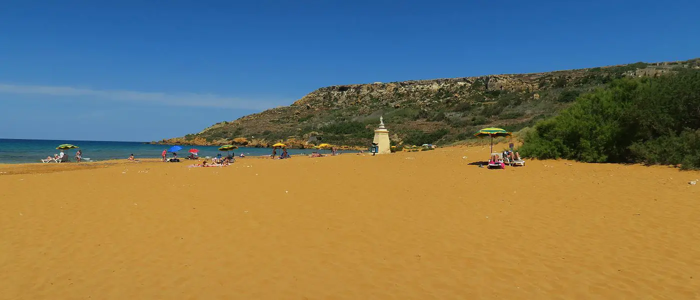 Ein Strand auf Maltas Nachbarinsel Gozo mit rötlichen Sand und sonnigen Wetter im November.