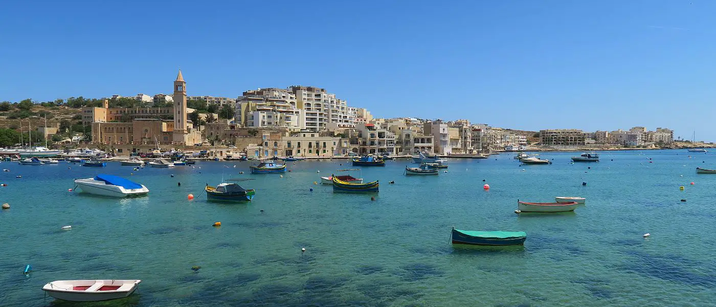 Die Einwohner von Malta und ihre Luzzo Boote im türkisblauen Meer des Hafens von Marsaskala.