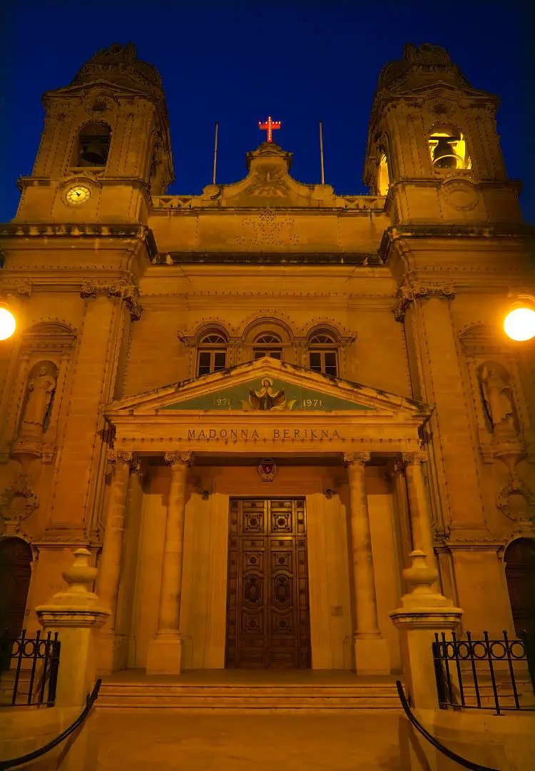 Eine Kirche mit einem Neon-Kreuz uf der Spitze. 