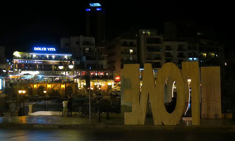 Das LOVE Sign in Spiegelschrift und die Spinola Bay in der Nacht. 