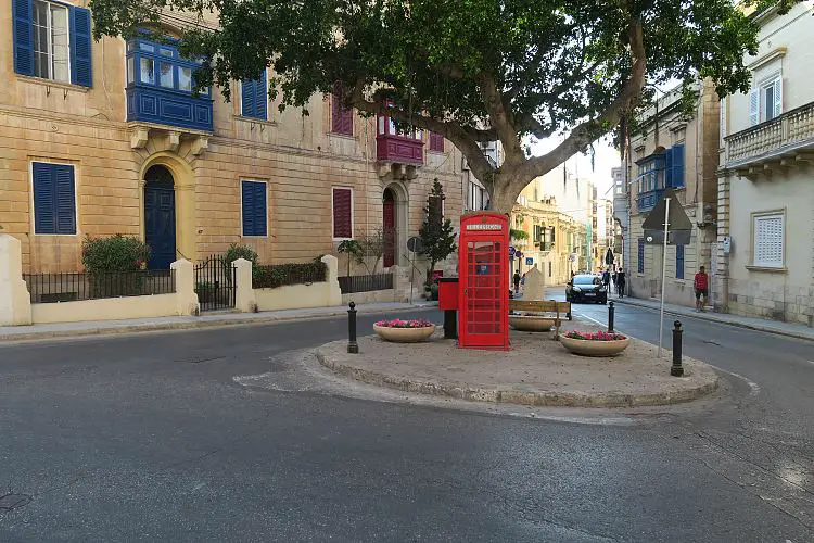 Ein kleiner Kreisverkehr mit einer britischen Telefonzelle in der Innenstadt von Sliema, auf Malta.