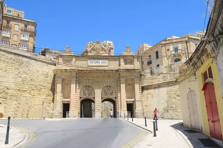 Der Blick vom Hafen auf das aus drei Torbögen bestehende, weiße Victoria Gate und die Stadtmauern.