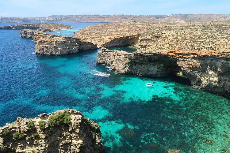 Gozo Comino Blick von den rund 100m hohen Klippen im Süden von Comino auf das türkisblaue Meer und die Insel Gozo im Hntergrund.