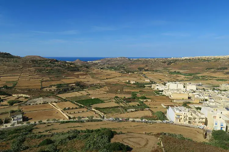 Blick von der Zitadelle in Victoria auf Felder in Gozo und das Meer.