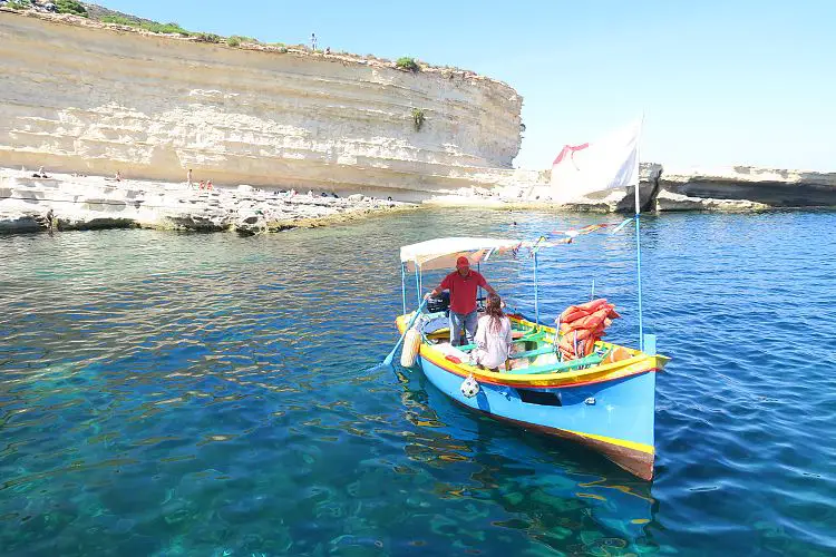 Luzzu Marsaxlokk Malta Meer ein buntes Luzzu Boot in blau-elb-roter Farbe fährt zum St. Peter´s Pool.