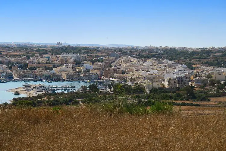 Die Stadt Marsaxlokk und der Hafen, von einem nahen Hügel aus gesehen.