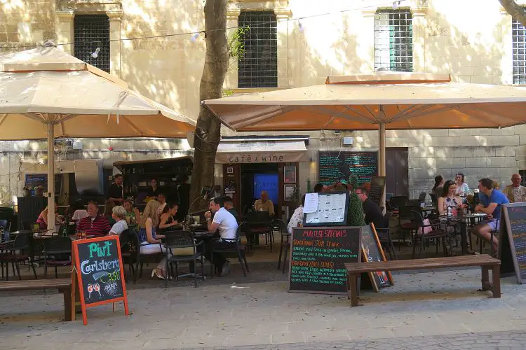 Der Gastgarten eines mit Sonnenschirmen überdachten Restaurants.