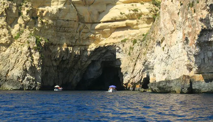 Zwei Boote nahe einer Grotte am Meer. 