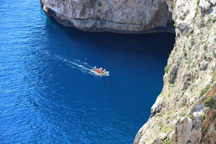 Kleines Boot unter dem natürlichen Felsbogen an der Blauen Grotte. 