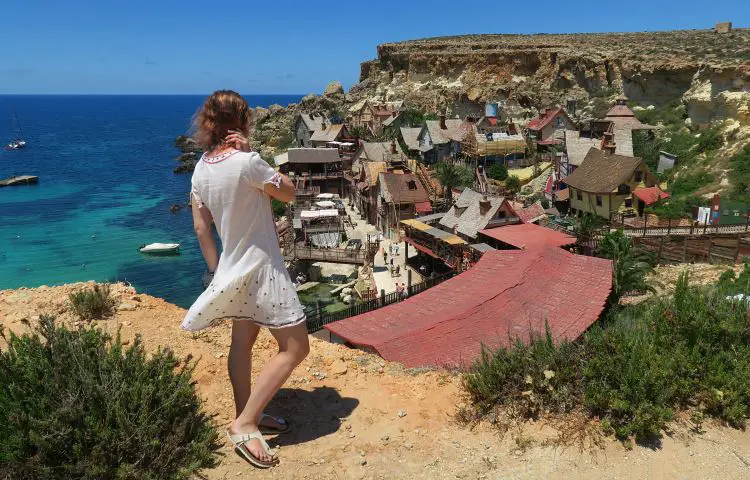 Frau steht oberhalb der Klippen am Popeye Village