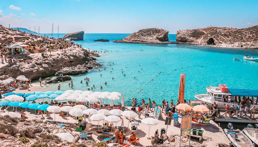 Berühmte Blaue Lagune auf der Nachbarinsel Comino mit Sonnenliegen und dem türkisblauen Meer