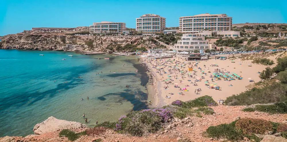 Golden Bay Sandstrand mit Hotels, Sonnenliegen und dem Meer