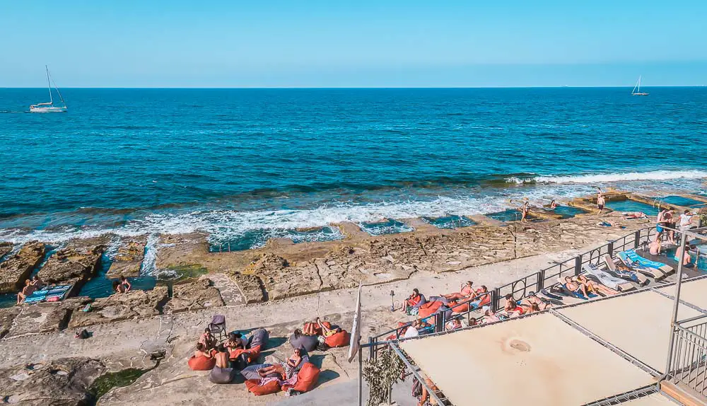 Steinstrand an der Küste mit Badegästen